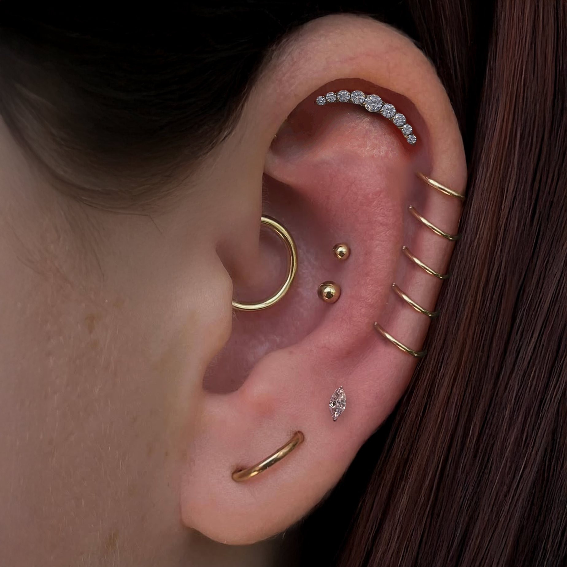 pierced ear curation with gold and titanium jewelry
