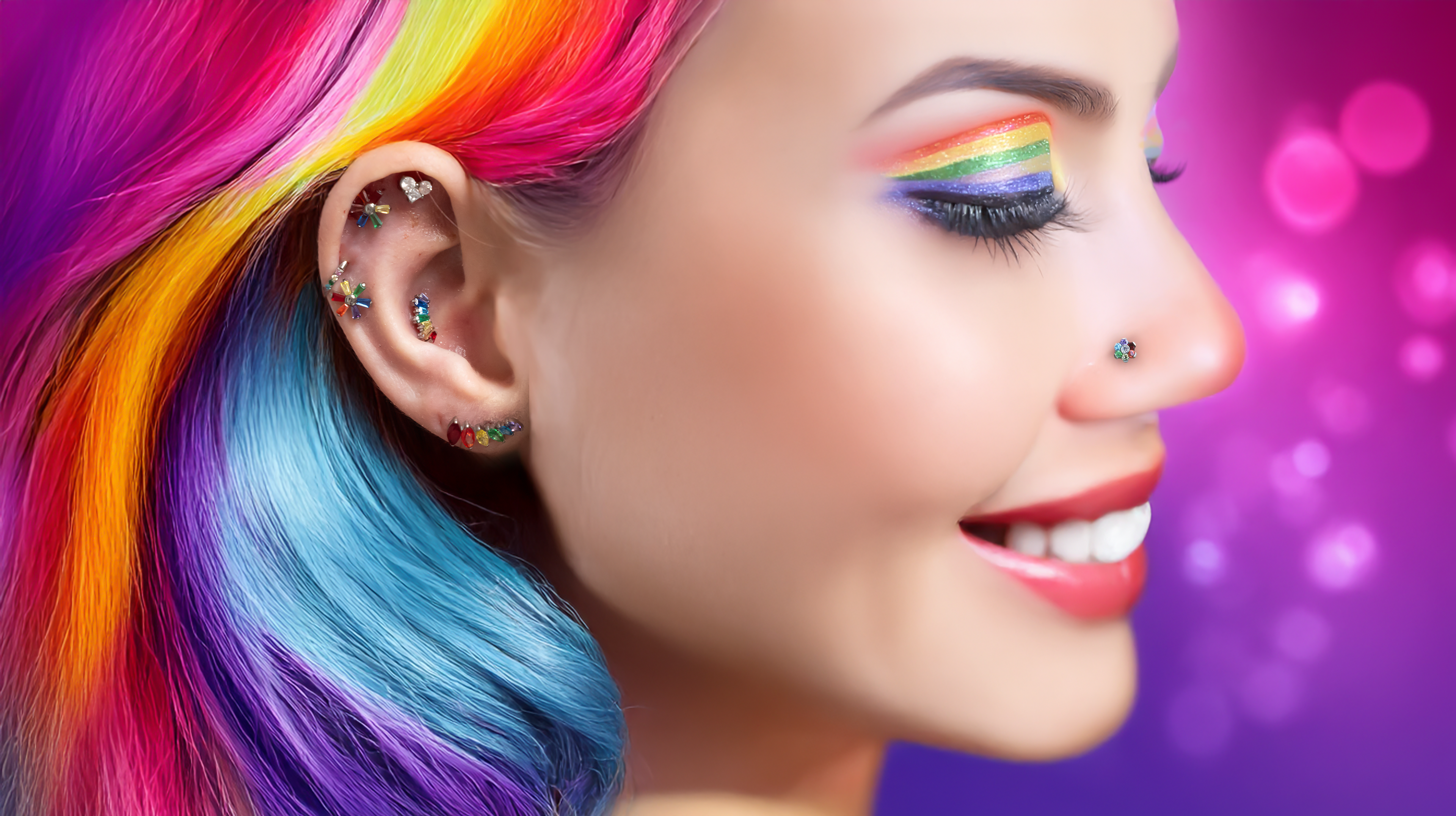 woman with rainbow hair and pride themed rainbow jewelry is celebrating Pride