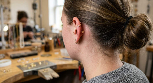 back of woman's ear with curated piercings