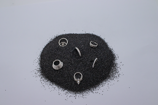 titanium hinged rings arranged in a circle of black sand