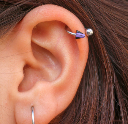 side view of an ear with a cartilage and ear lobe piercing