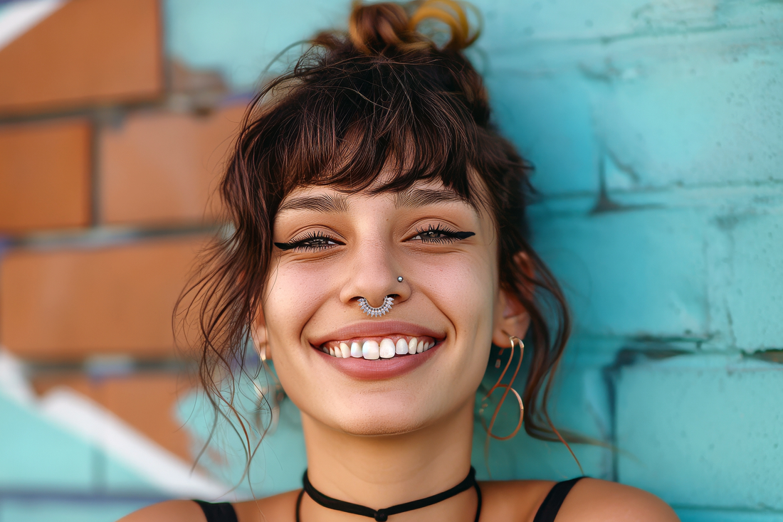 woman with septum and nostril piercing standing up against a brick wall