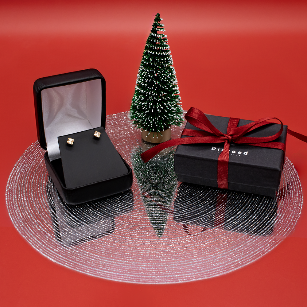 earrings in a jewelry gift box with a bottle brush tree on a red holiday background
